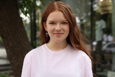 Portrait of beautiful teenage girl on city street