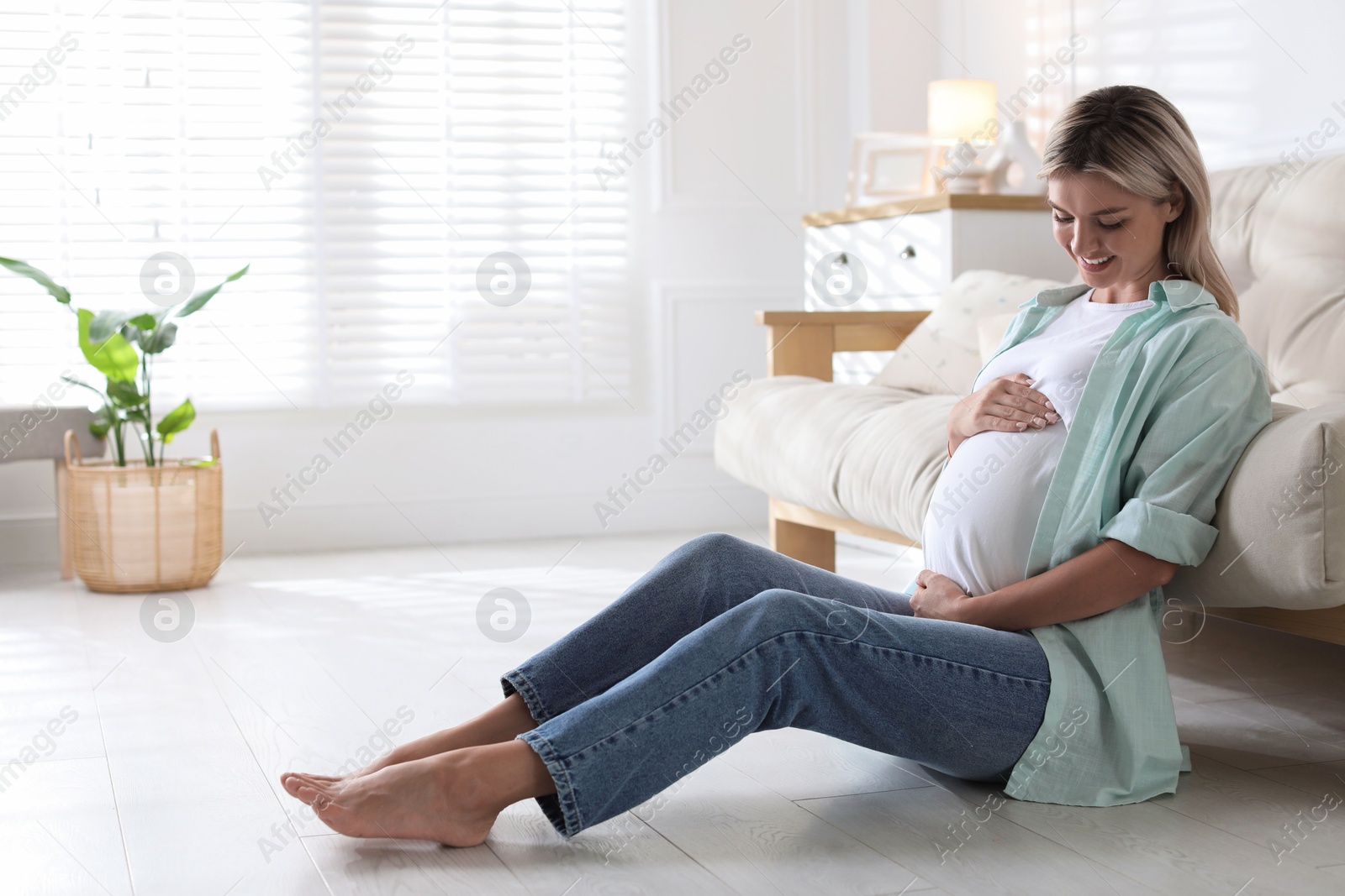 Photo of Portrait of beautiful pregnant woman on floor at home