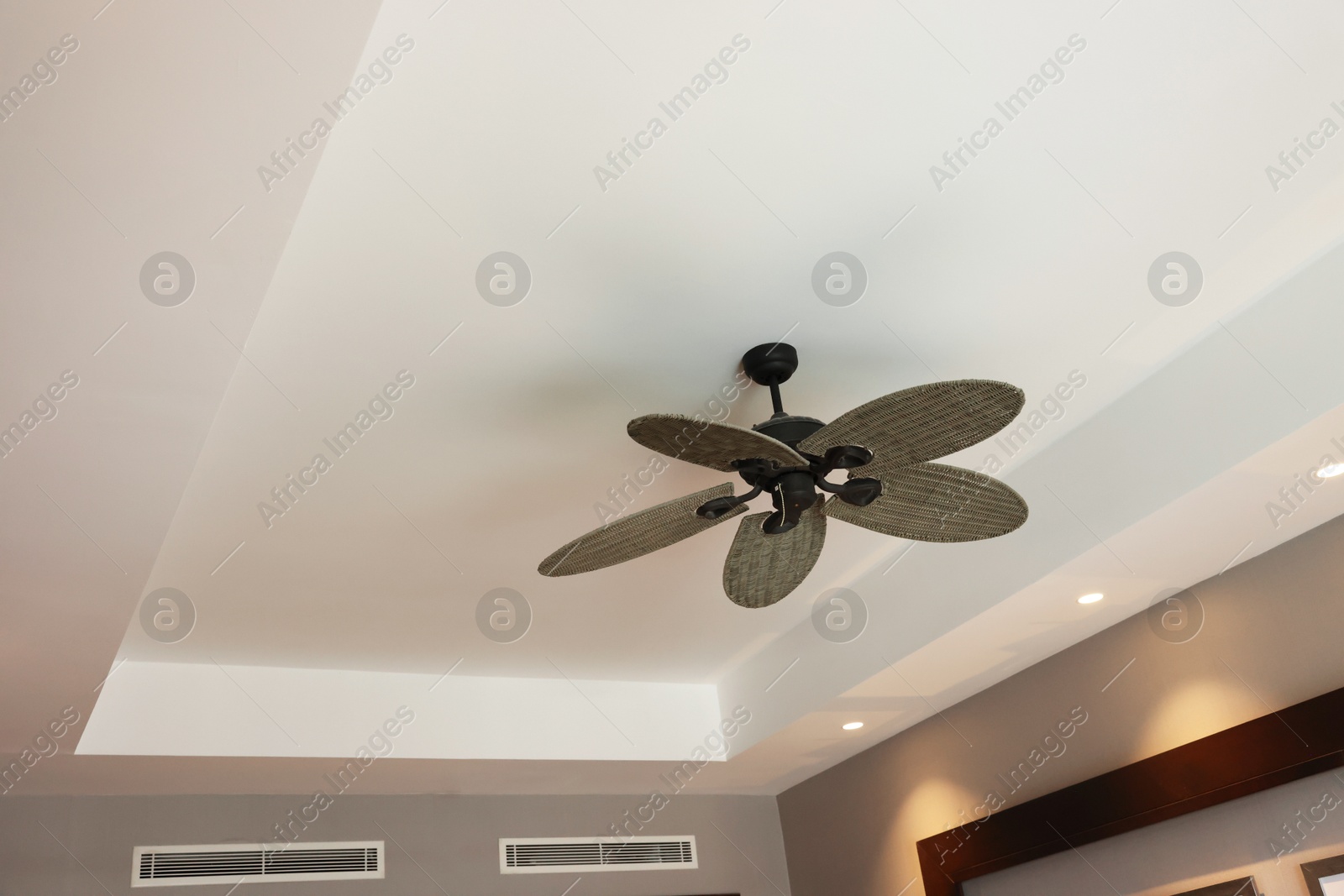 Photo of Modern ceiling fan indoors, low angle view