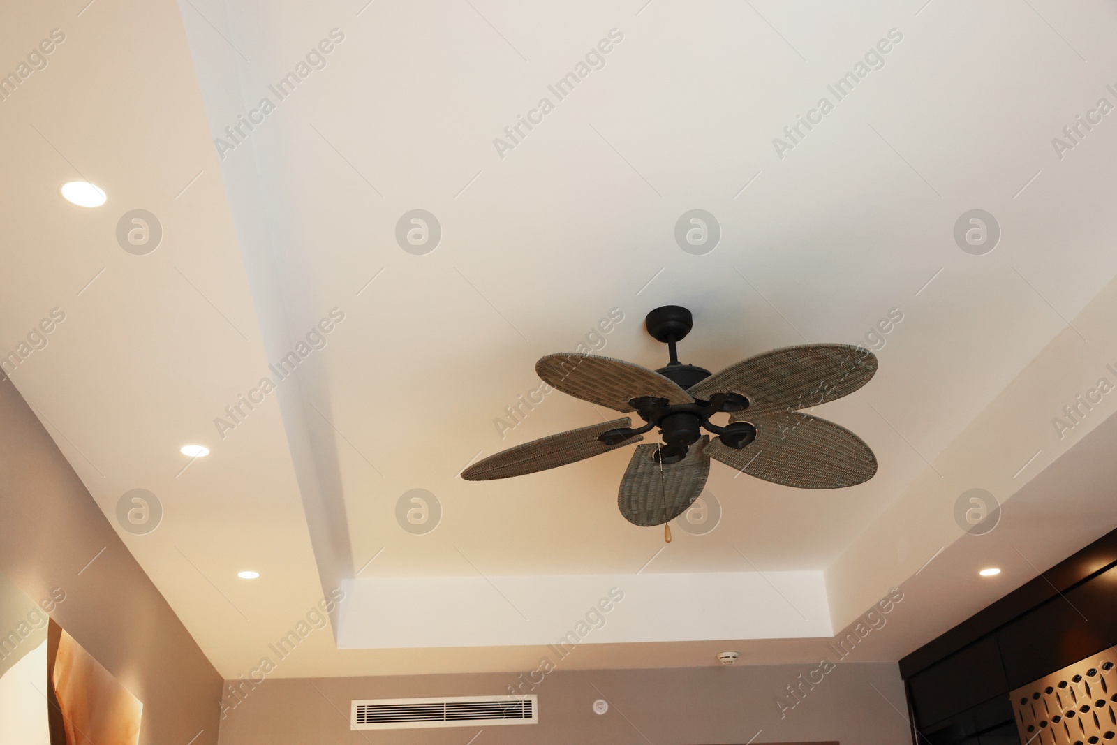 Photo of Modern ceiling fan indoors, low angle view