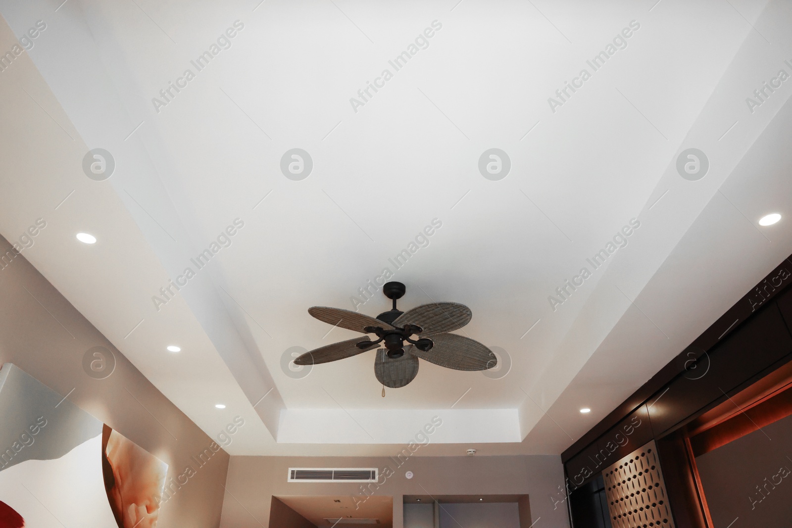 Photo of Modern ceiling fan indoors, low angle view