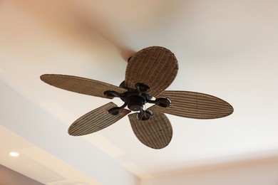 Photo of Modern ceiling fan indoors, low angle view