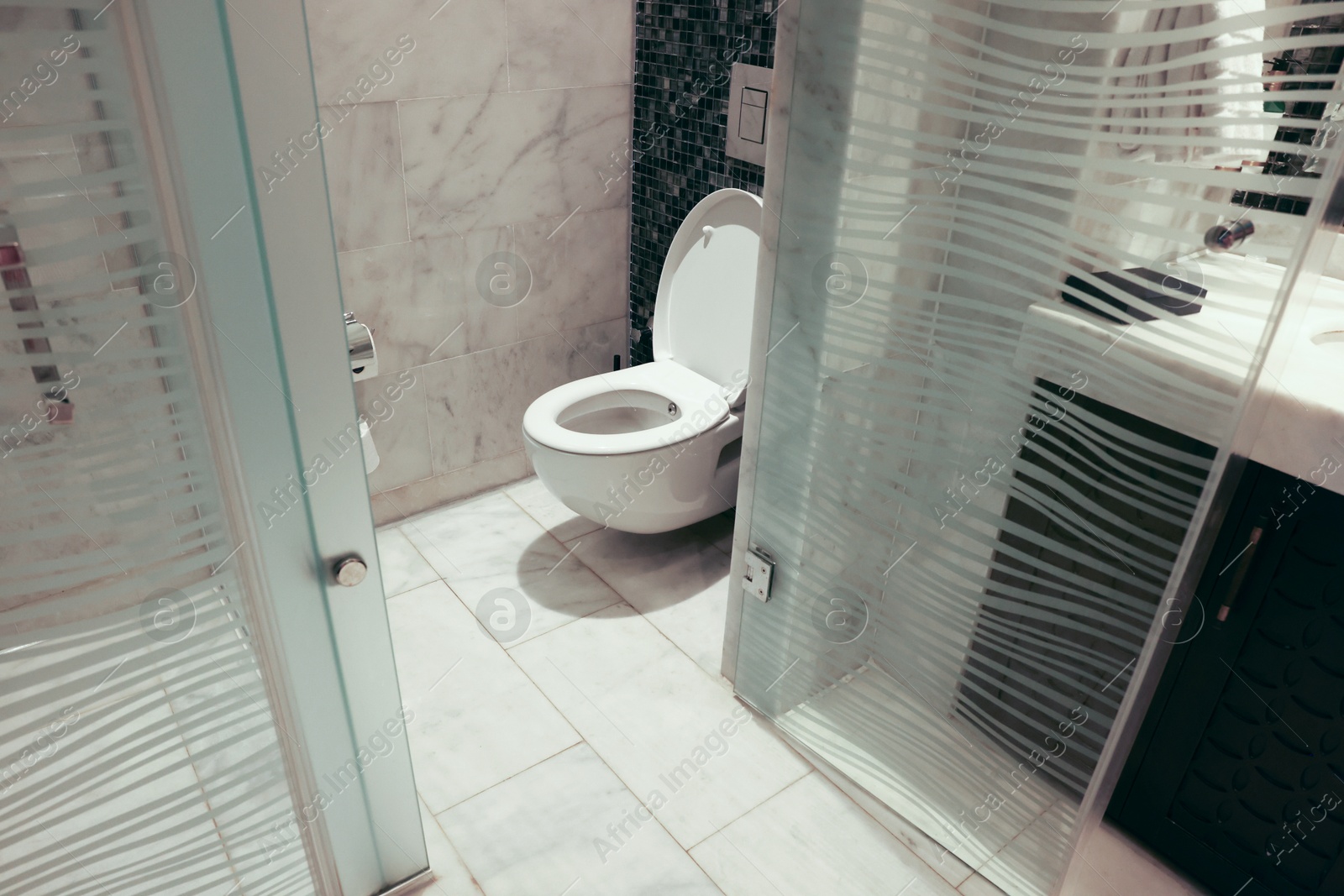 Photo of Ceramic toilet bowl and shower stall in bathroom