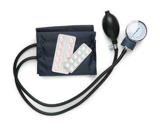 Photo of Blood pressure measuring device and pills in blisters isolated on white, top view