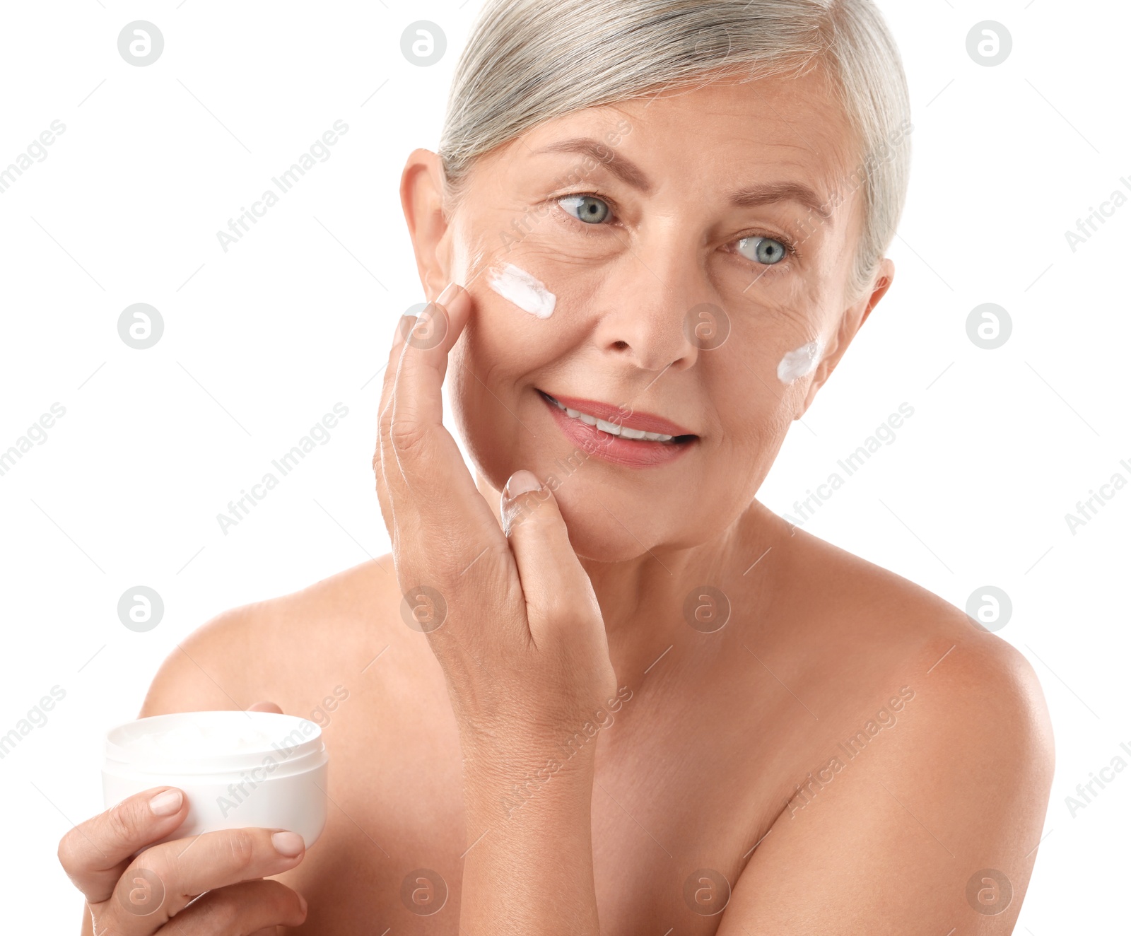 Photo of Senior woman applying face cream on white background