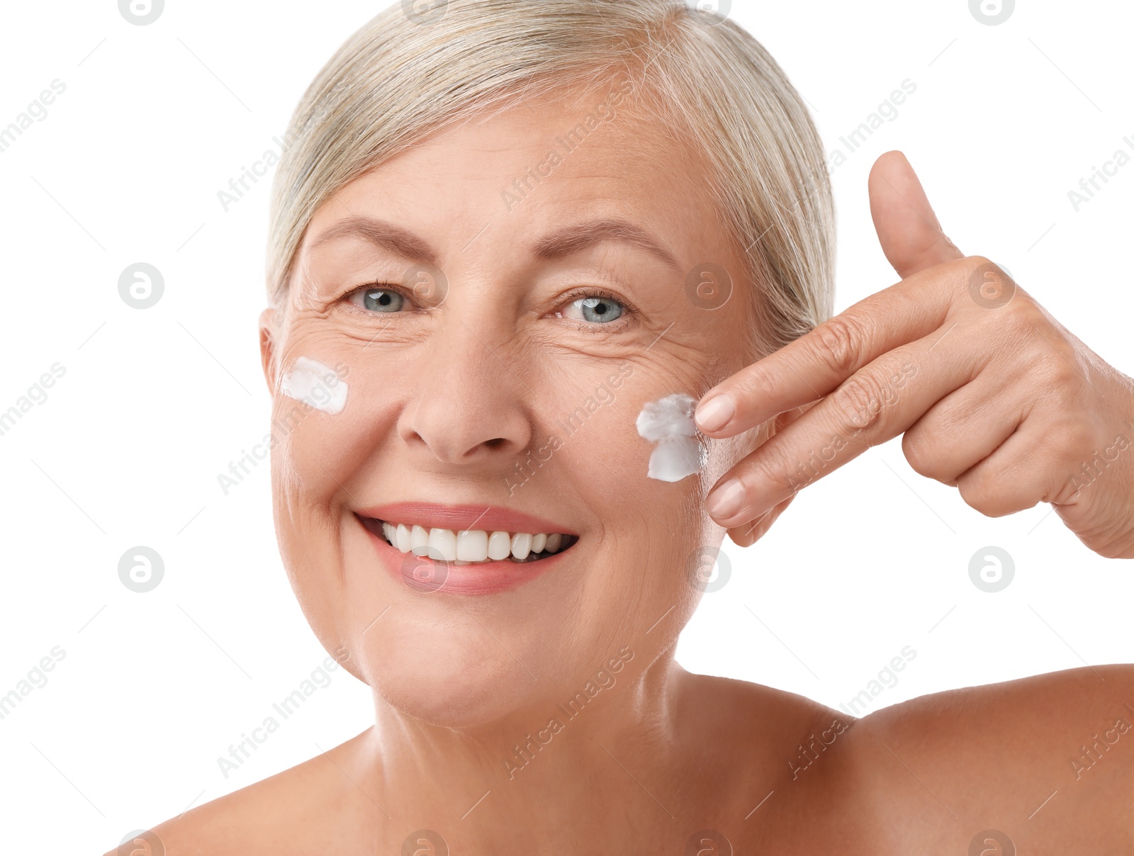 Photo of Senior woman applying face cream on white background