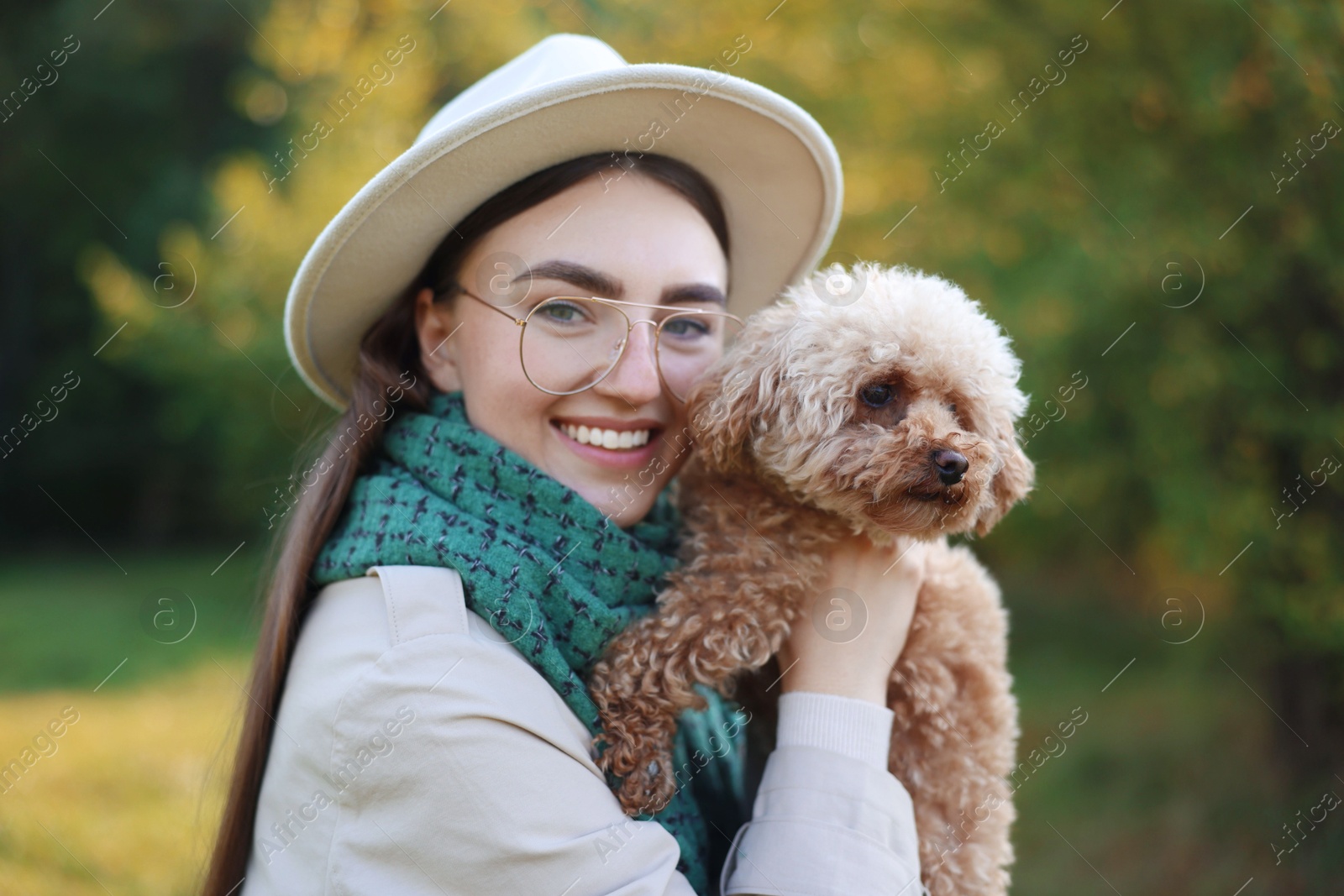 Photo of Smiling woman with cute dog in autumn park