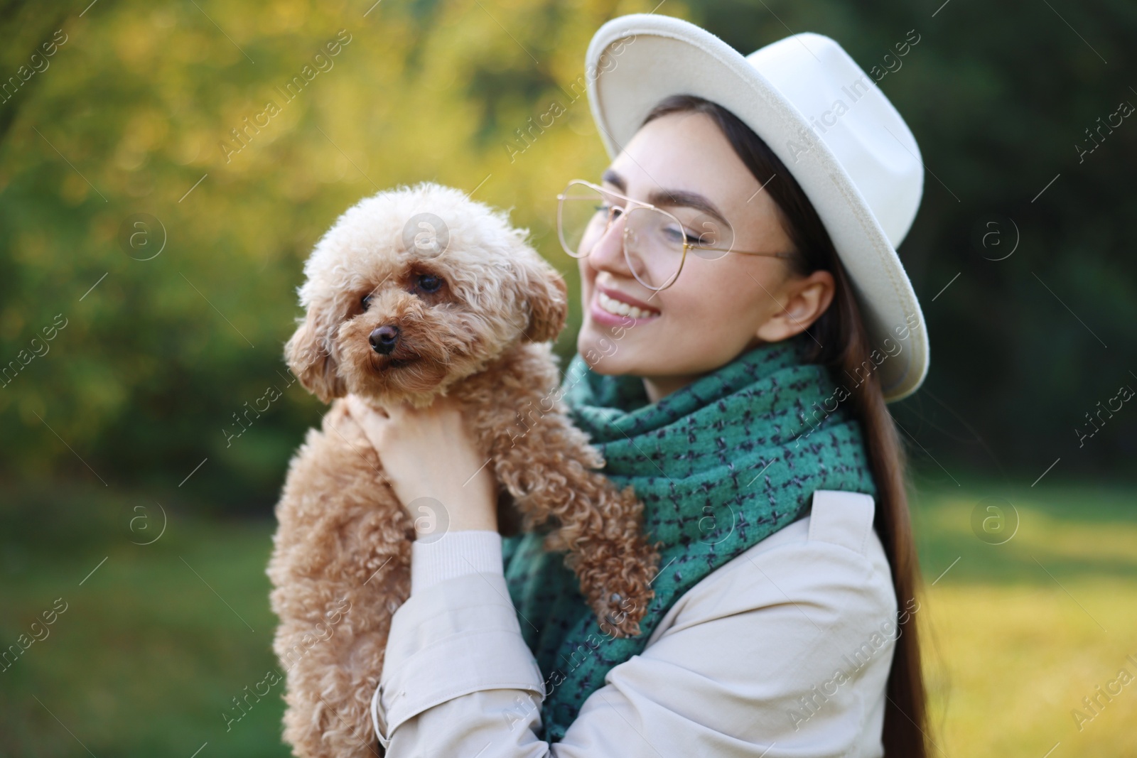 Photo of Smiling woman with cute dog in autumn park