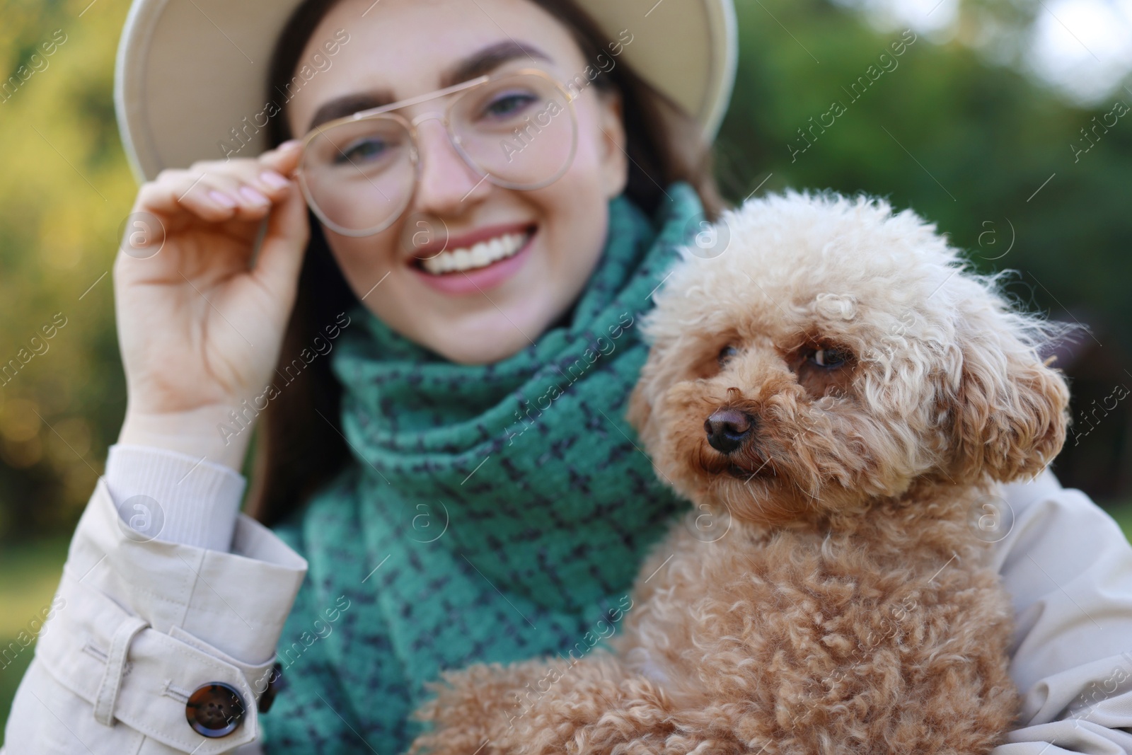 Photo of Portrait of smiling woman with cute dog outdoors