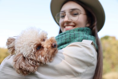 Smiling woman with her cute dog outdoors