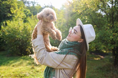 Photo of Woman with cute dog in autumn park on sunny day