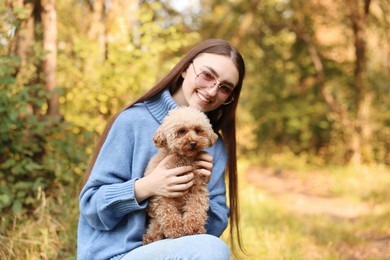 Photo of Smiling woman with cute dog in autumn park