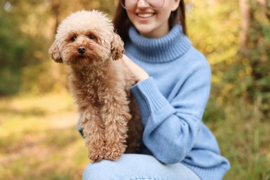 Smiling woman with cute dog outdoors, closeup