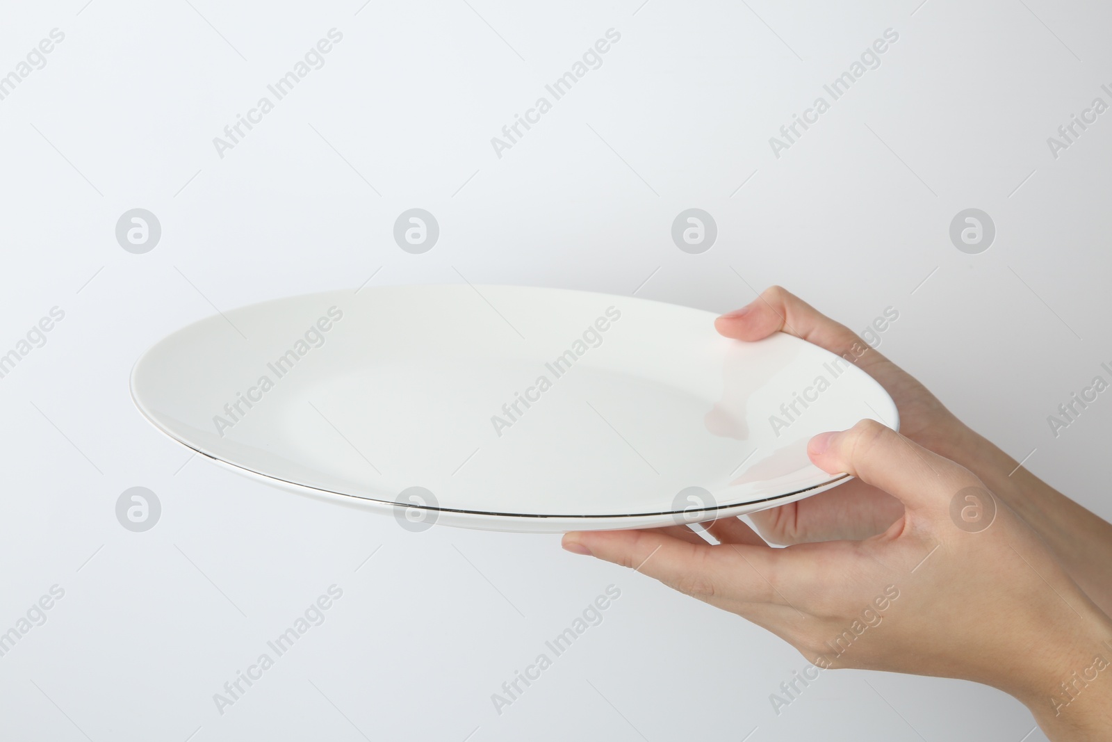 Photo of Woman with empty ceramic plate on white background, closeup