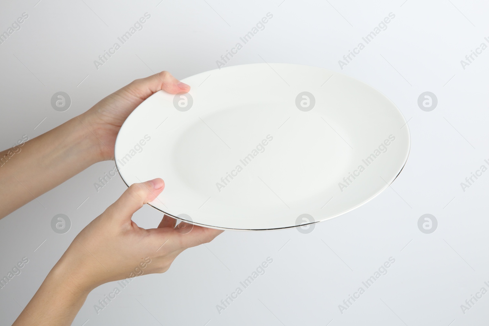 Photo of Woman with empty ceramic plate on white background, closeup