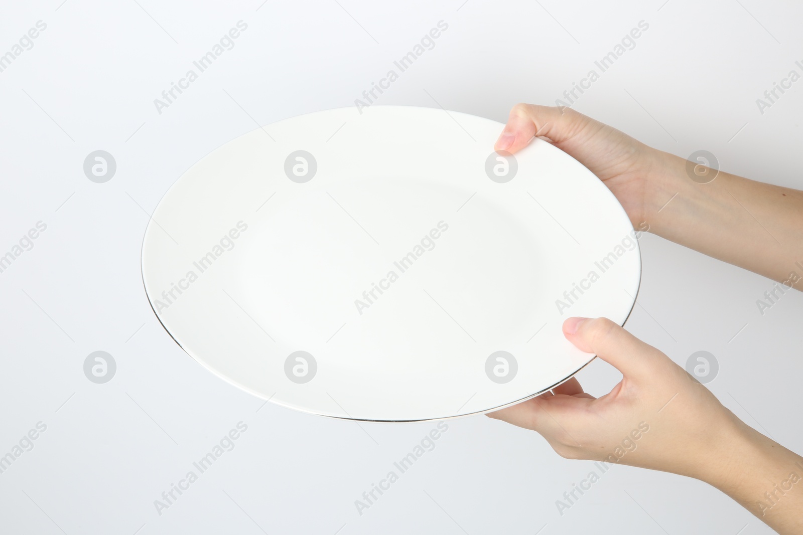 Photo of Woman with empty ceramic plate on white background, closeup