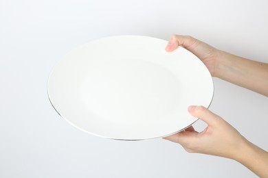 Photo of Woman with empty ceramic plate on white background, closeup