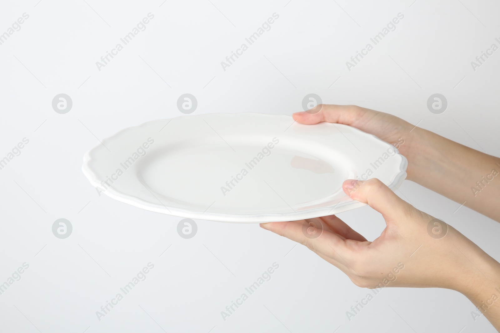 Photo of Woman with empty ceramic plate on white background, closeup