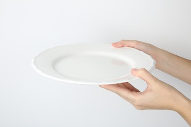 Photo of Woman with empty ceramic plate on white background, closeup