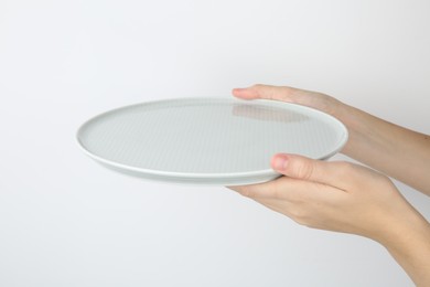 Photo of Woman with empty ceramic plate on white background, closeup