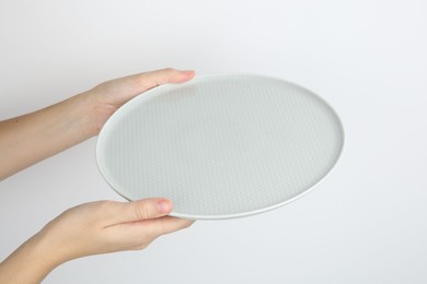 Photo of Woman with empty ceramic plate on white background, closeup