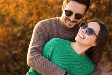 Photo of Beautiful happy couple hugging outdoors in autumn evening