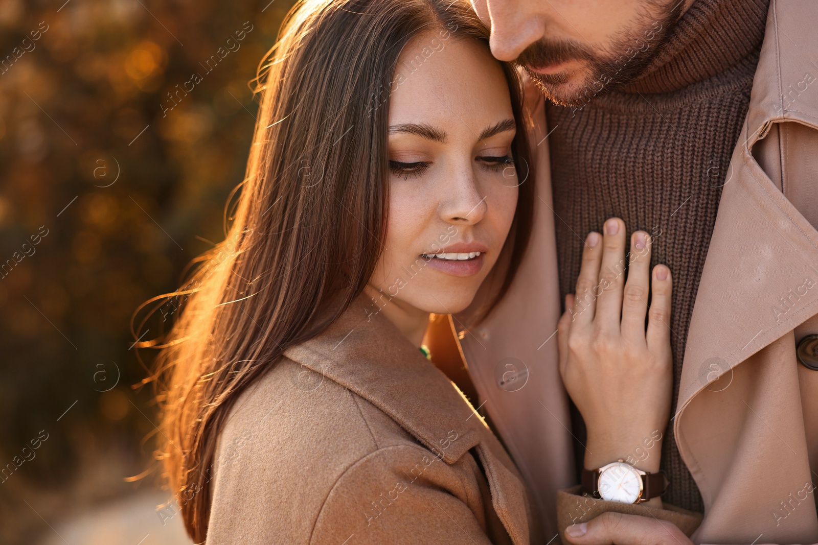 Photo of Beautiful couple hugging in autumn park, closeup