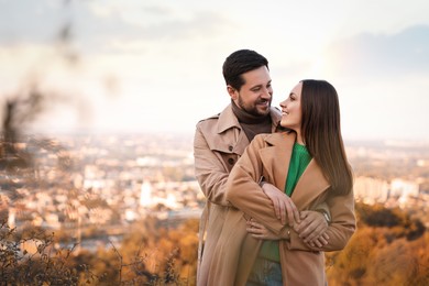 Beautiful couple hugging outdoors on autumn day, space for text