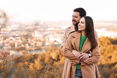 Beautiful couple hugging outdoors on autumn day, space for text