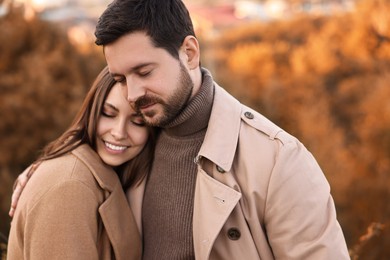 Photo of Beautiful couple hugging in park on autumn day