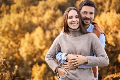 Photo of Beautiful couple spending time together outdoors on autumn day, space for text