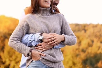 Couple hugging outdoors on autumn day, closeup view