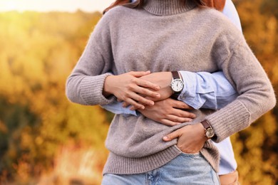 Photo of Couple hugging outdoors on autumn day, closeup view