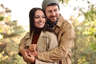 Photo of Beautiful happy couple hugging outdoors on autumn day