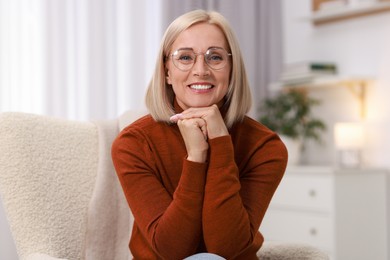 Photo of Portrait of smiling middle aged woman on armchair at home