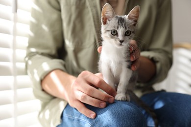 Man with cute kitten at home, closeup