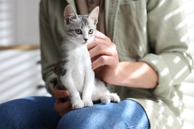 Photo of Man with cute kitten at home, closeup