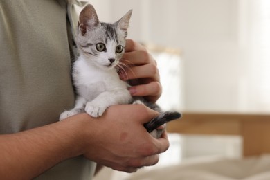 Photo of Man with cute kitten at home, closeup