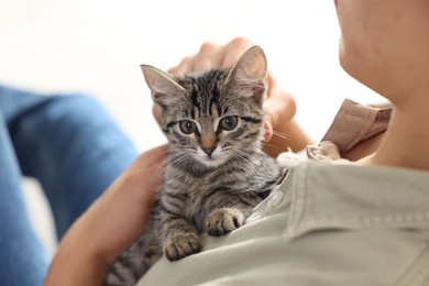 Man with cute kitten at home, closeup