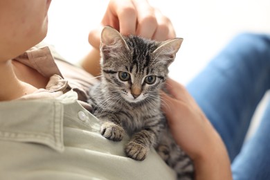 Photo of Man with cute kitten at home, closeup