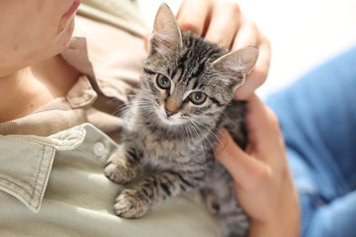 Photo of Man with cute kitten at home, closeup