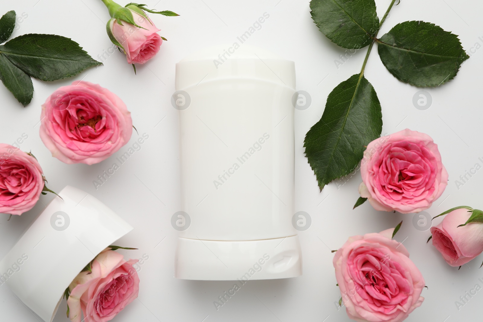 Photo of Solid deodorant and beautiful rose flowers on white background, flat lay