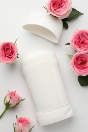 Photo of Solid deodorant and beautiful rose flowers on white background, flat lay