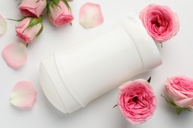 Photo of Solid deodorant and beautiful rose flowers on white background, flat lay