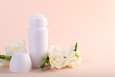 Photo of Roll-on deodorant and beautiful eustoma flowers on beige background