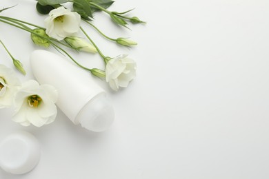 Photo of Roll-on deodorant and beautiful eustoma flowers on white background, flat lay. Space for text