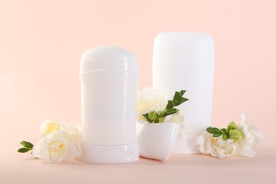 Photo of Solid deodorants and beautiful eustoma flowers on beige background