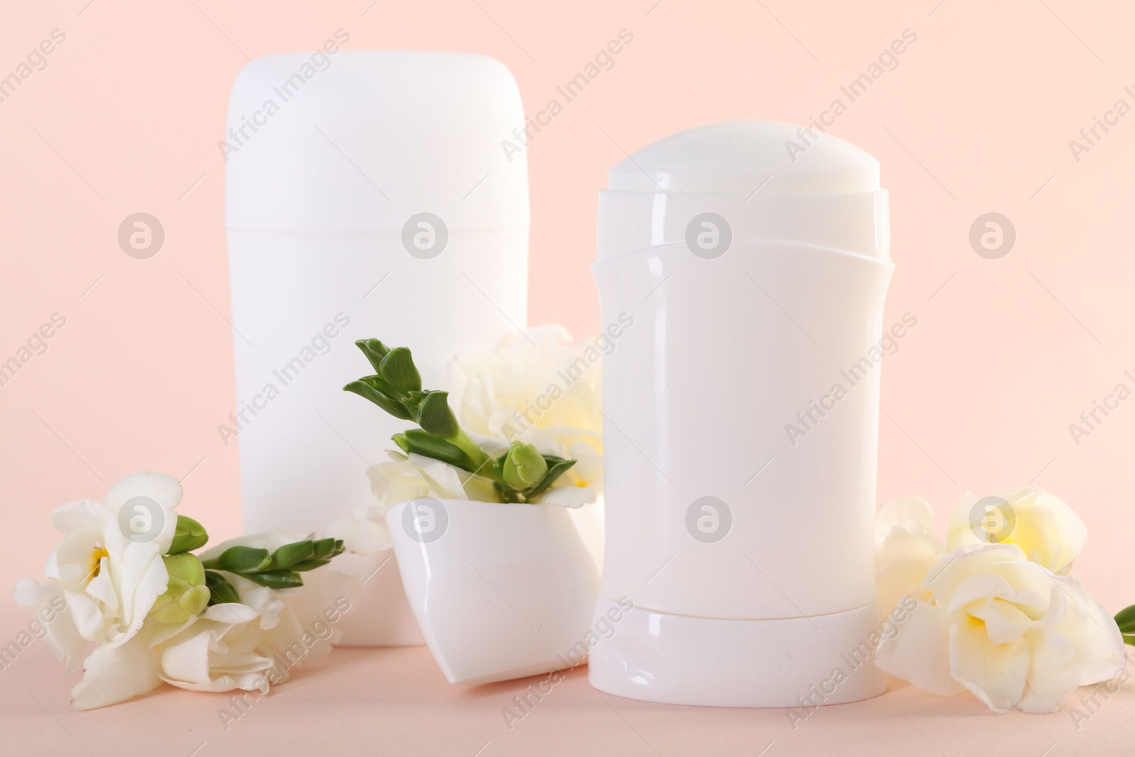 Photo of Solid deodorants and beautiful eustoma flowers on beige background