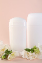 Photo of Solid deodorants and beautiful eustoma flowers on beige background