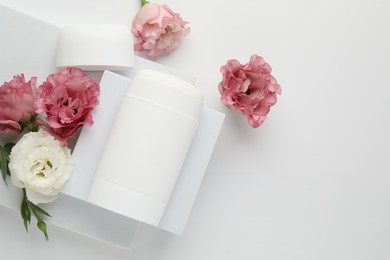 Photo of Solid deodorant and beautiful eustoma flowers on white background, top view